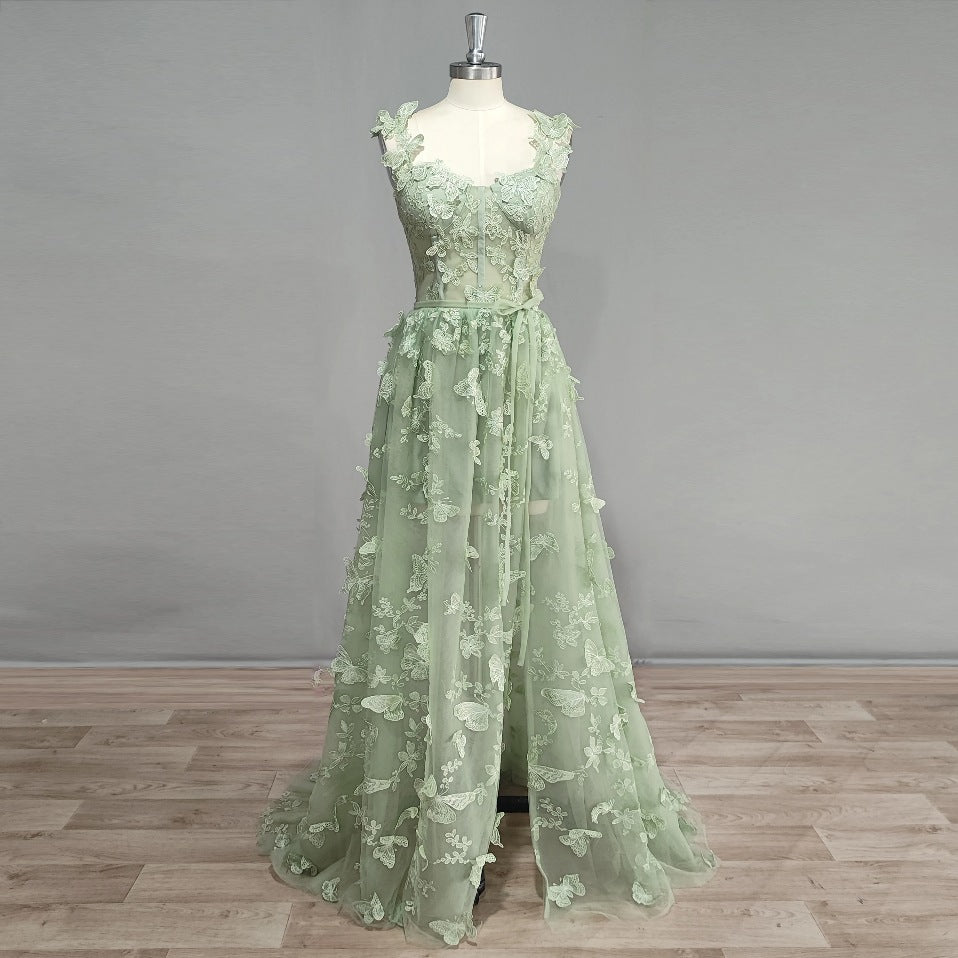 Model of a sage green tulle prom dress featuring 3D butterfly appliques, sweetheart neckline, boning and and high slit.