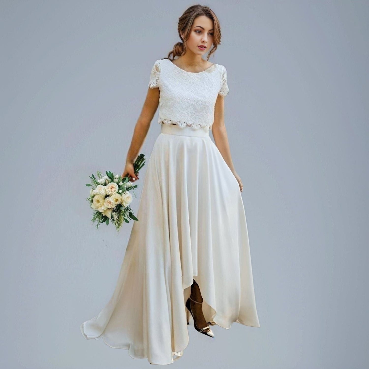 Bride in a two-piece bridal gown with a fully laced top, short cap sleeves, and an asymmetrical high-low skirt with a sweeping train.