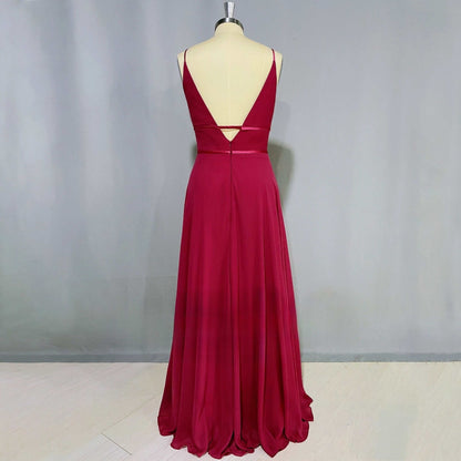 Mannequin wearing a floor-length burgundy A-line dress with an open back and spaghetti straps, perfect for elegant evening events.