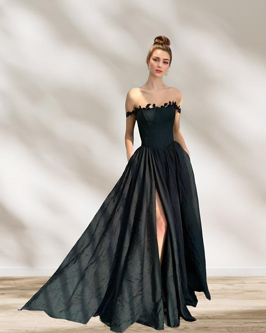 Full-length shot of woman in LACIE black formal dress with flowing A-line skirt and slit.