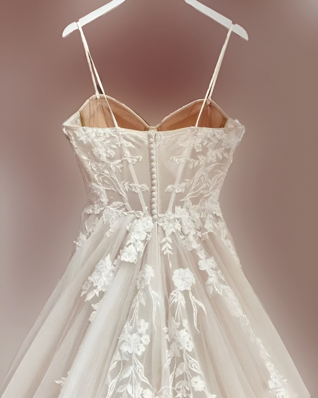 Back of LEONA wedding dress on a stylish hanger, set against a soft background, capturing the gown's romantic essence.