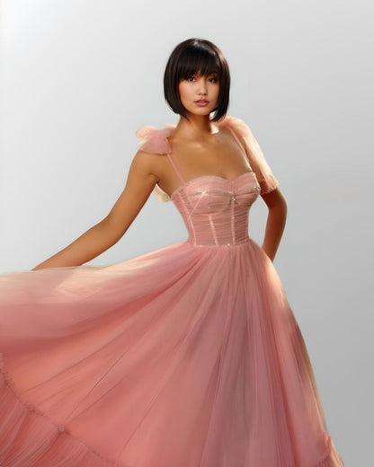 WOman wearing pink LITZY dress with flowing tulle.
