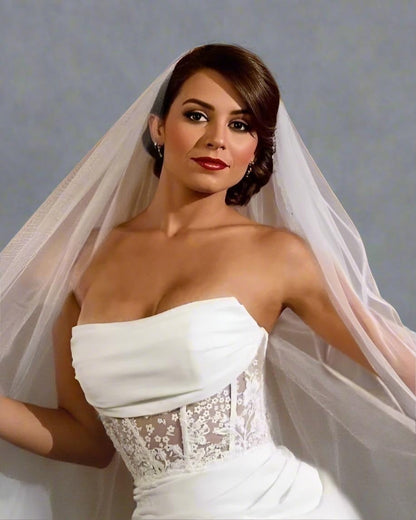Woman wearing a white wedding dress with a veil against a gray background
