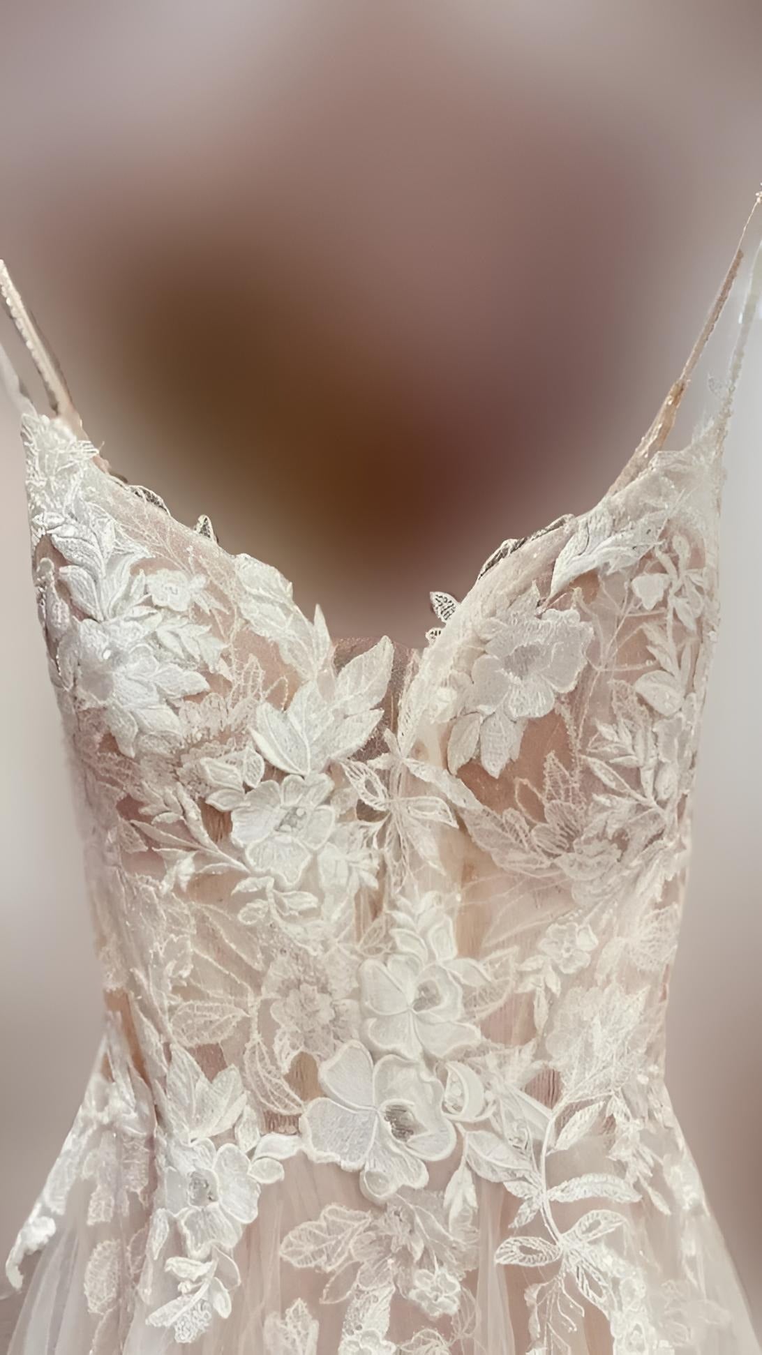 Detail shot of the flower lace design on the bodice of romantic bohemian Nina Wedding Dress.