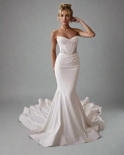 Woman in Oleandra strapless wedding dress with figure-hugging silhouette and sweep train