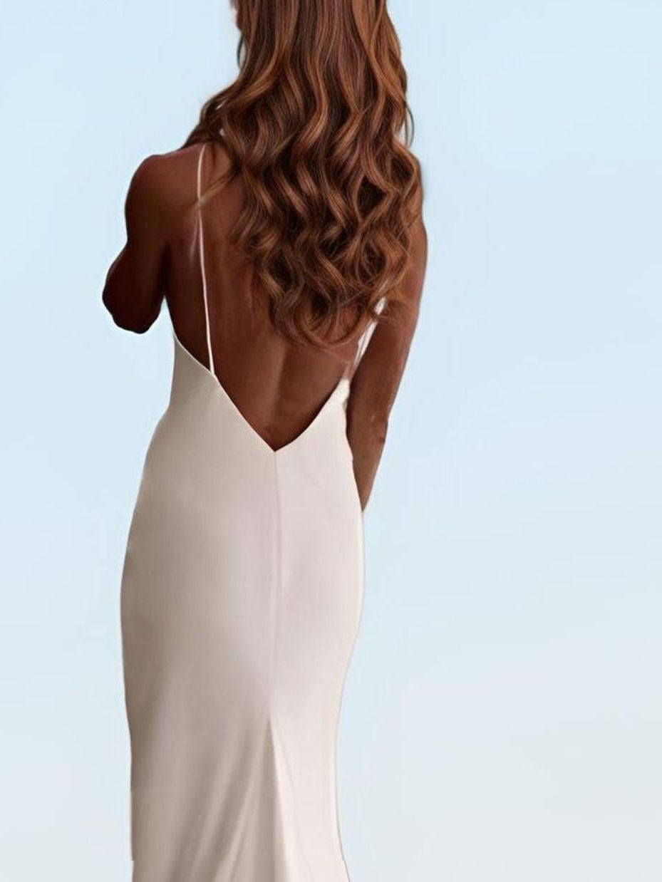 Woman showcasing a detail of low back V cut on a wedding dress.