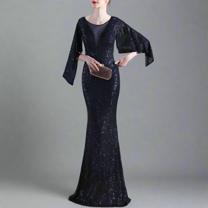 Woman in a sparkly navy evening gown holding a clutch in studio setting.
