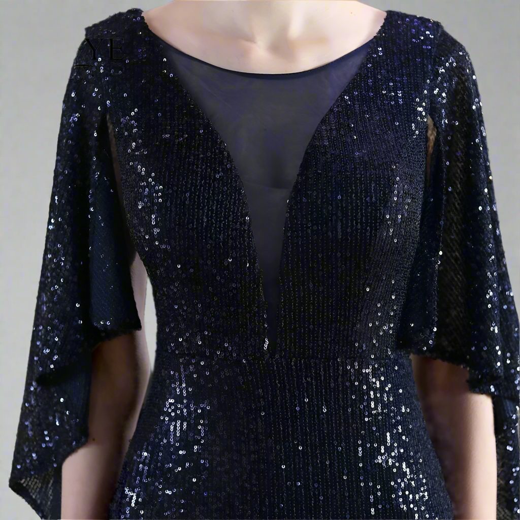 Woman showing detail of navy sequin dress on against a neutral background