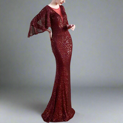 Woman wearing a burgundy sequin dress with a matching jacket indoors.