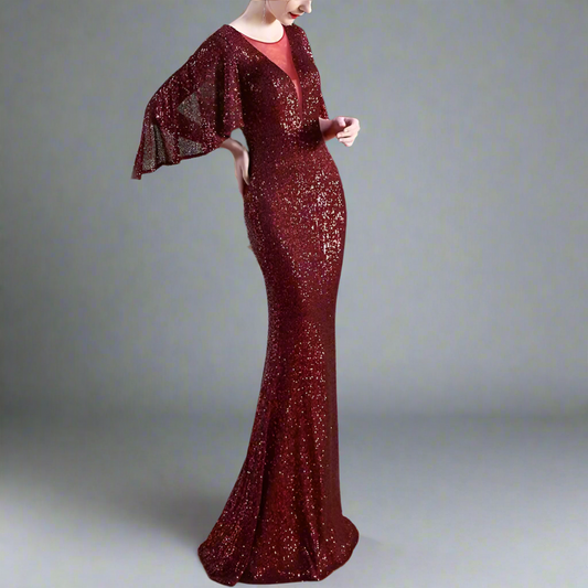 Woman wearing a burgundy sequin dress with a matching jacket indoors.