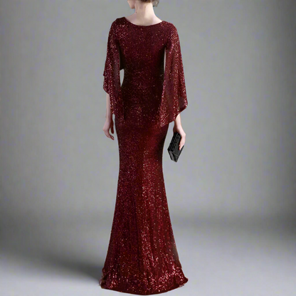 Woman wearing a burgundy sequin dress with bat sleeves from back.