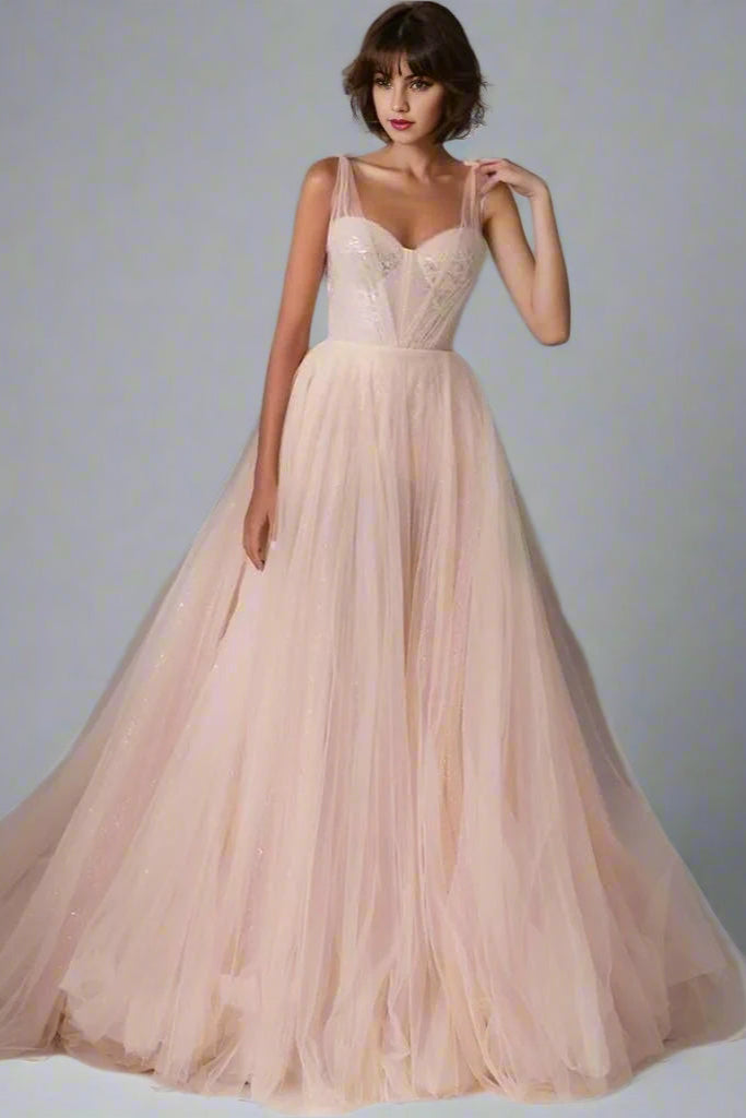 Woman in romantic formal gown with tulle overlay and intricate lace details.