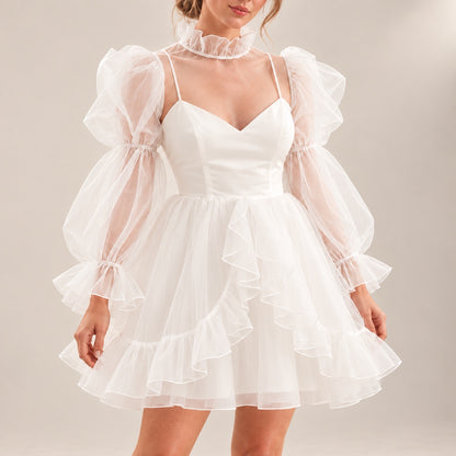 Close-up of ALLANAH wedding dress showing the fitted V-neck bodice, sheer long sleeves and cascading skirt ruffles.