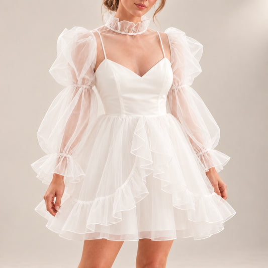 Close-up of ALLANAH wedding dress showing the fitted V-neck bodice, sheer long sleeves and cascading skirt ruffles.