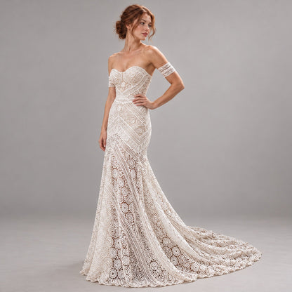 An off-the-shoulder lace wedding gown with a sweetheart neckline, fitted bodice, and dramatic train, shown on a model against a neutral gray studio background.