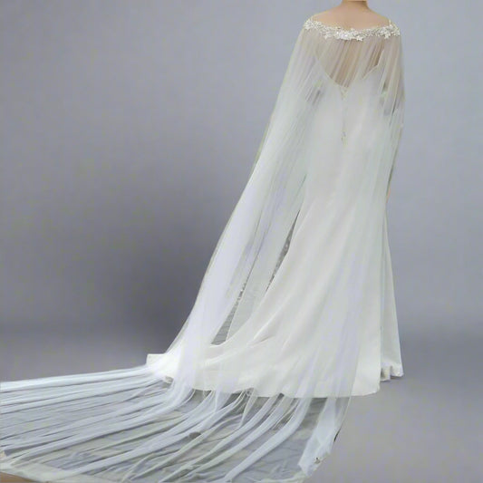 Bride wearing rhinestone beaded wedding cape with 3-meter cathedral veil.