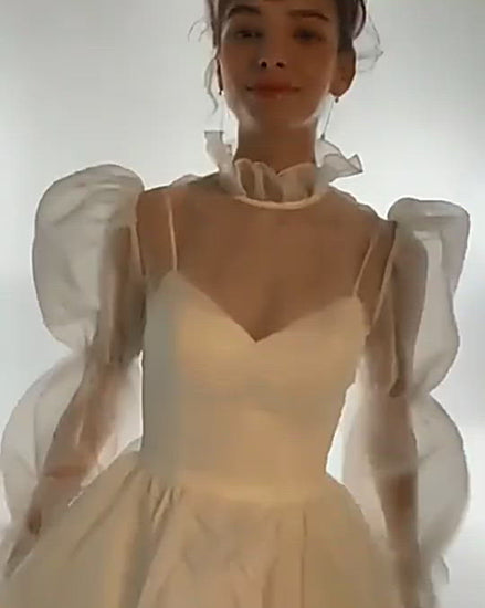 Video detailing view of Allanah elopement wedding gown with long sleeves, high neck, and ruffles